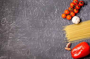 Dağınık makarna, sarımsak, domates, gri arka plan üzerinde