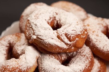 beyaz bir tepside pudra şekeri serpilir çörek