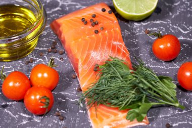 Gri bir arka plan, domates, dereotu, zeytinyağı, limon somon parçası. Seçici odak,