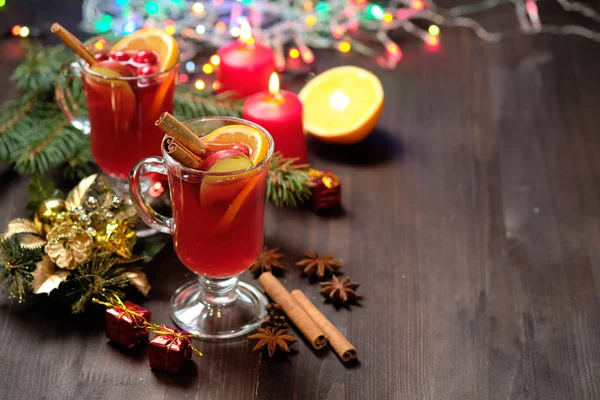 Vino caliente sobre fondo de madera con velas, ramas de pino y luces navideñas. Enfoque selectivo. Copiar espacio — Foto de Stock