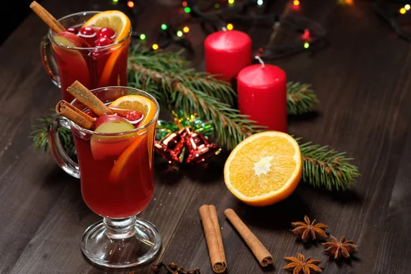 Glühwein op een houten achtergrond met kaarsen, pijnboomtakken en kerstverlichting. Selectieve aandacht — Stockfoto