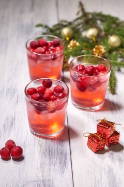 Gözlük çam dalı arka planda beyaz ahşap zemin üzerine kızılcık suyu ile. Noel ağacı