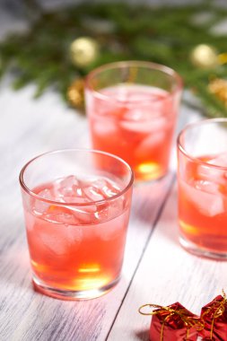 Gözlük çam dalı arka planda beyaz ahşap zemin üzerine kızılcık suyu ile. Noel ağacı