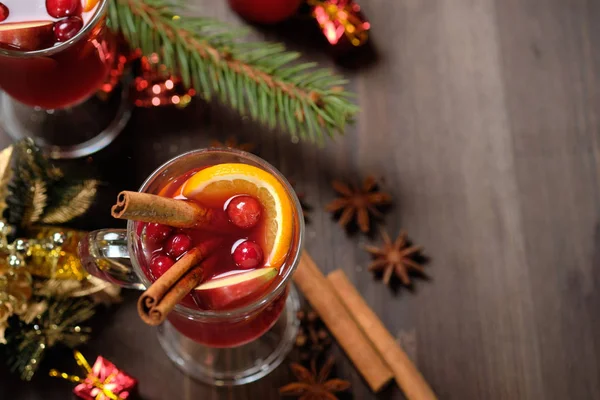 Vino caliente sobre fondo de madera con velas, ramas de pino y luces navideñas. Enfoque selectivo. Copiar espacio — Foto de Stock