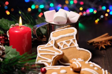 Zencefilli bisküvi ve lokum Noel ağacı, mumlar ve Noel ışıkları kahverengi zemin üzerine. 