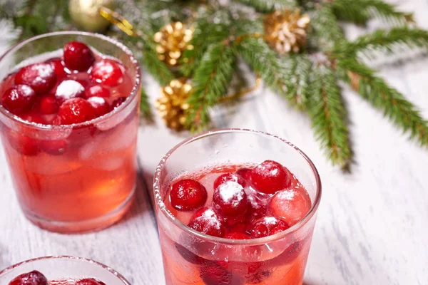 Glasses with cranberry juice on white wooden background with pine branch in the background. Christmas tree — Stock Photo, Image