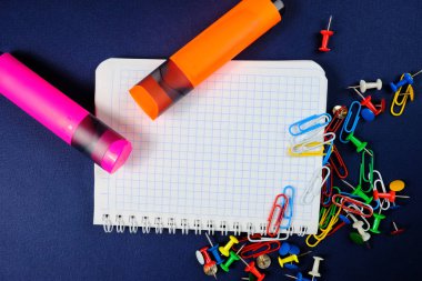 Öğrenci yarıyıl not defteri üzerinde mavi arka plan, seçili areaand renkli klipleri ve işaretleri bir dack mavi zemin üzerine spiral not defteri. Yakın çekim