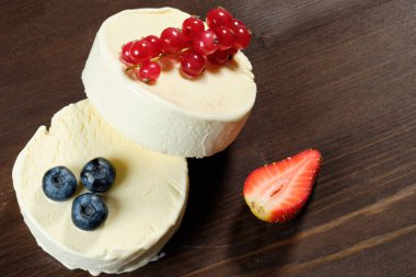 İki dondurma o çilek, yaban mersini ve dack ahşap arka plan üzerinde kırmızı kuş üzümü ile beyaz