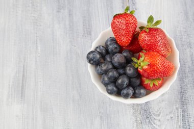 Gri bir ahşap zemin üzerine çilek