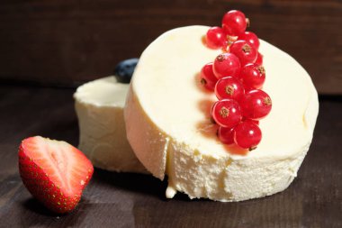 İki dondurma o çilek, yaban mersini ve dack ahşap arka plan üzerinde kırmızı kuş üzümü ile beyaz