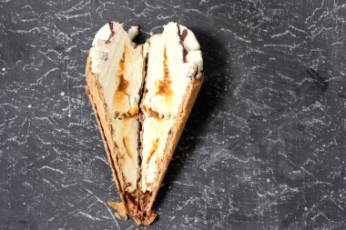 vanilyalı dondurma waffle koni ile koyu gri arka planda bir kesim karamel