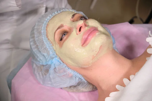 Ο αισθητικός φτιάχνει μάσκα προσώπου για τον ασθενή της. Αντιγηραντική και εξομάλυνση διαδικασία σε ένα σαλόνι ομορφιάς. Γιατρός σε μια αισθητολογική κλινική που κάνει μια θεραπεία της φροντίδας του δέρματος — Φωτογραφία Αρχείου