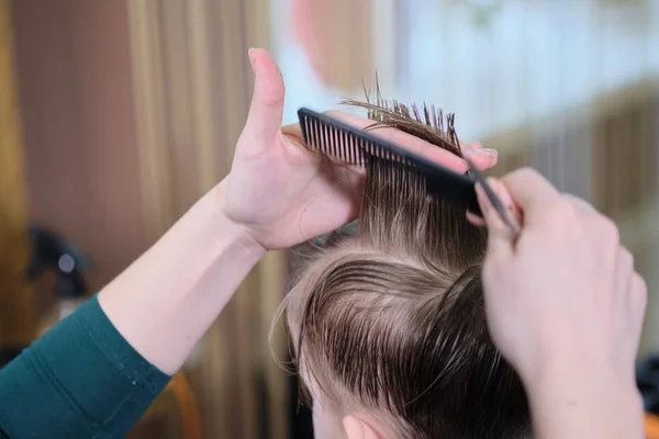 Frisör salong. Frisör gör frisyr till en pojke med hår sax och svart kam. — Stockfoto