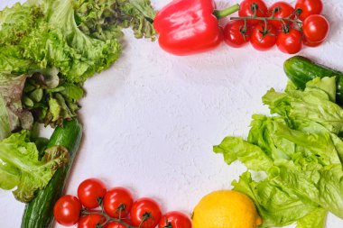 beyaz bir arka planda marul, salatalık, biber ve kiraz domates ile kopya alanı için çerçeve