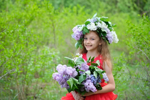 Bahar bahçesinde bir buket Lilya ve leylak çelenk ile bir kız — Stok fotoğraf