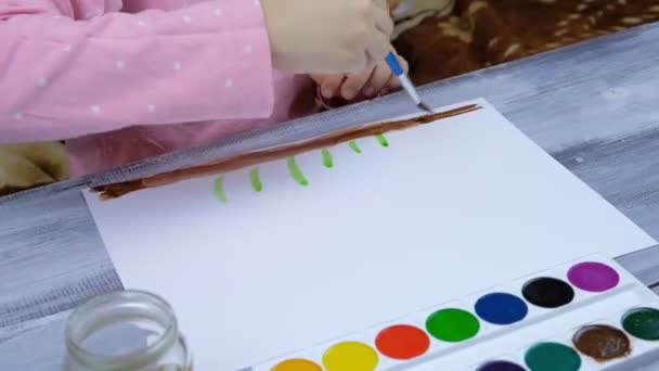Il bambino dipinge su un foglio bianco di carta — Video Stock