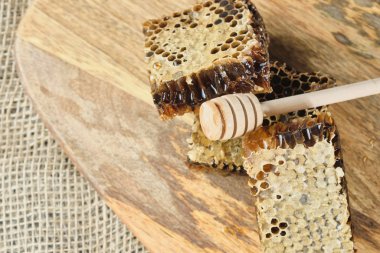 ahşap bir Tahta üzerinde bal ile petek ve bal için bir kaşık, seçici odak