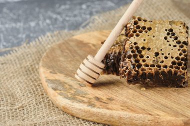 ahşap bir Tahta üzerinde bal ile petek ve bal için bir kaşık, seçici odak