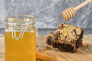 ahşap bir Tahta üzerinde bal ile petek, bal bir kaşık ile, seçici odak