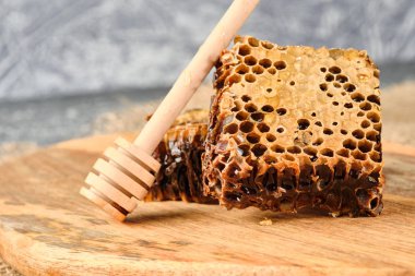 ahşap bir Tahta üzerinde bal ile petek ve bal için bir kaşık, seçici odak