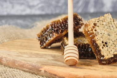 ahşap bir Tahta üzerinde bal ile petek ve bal için bir kaşık, seçici odak