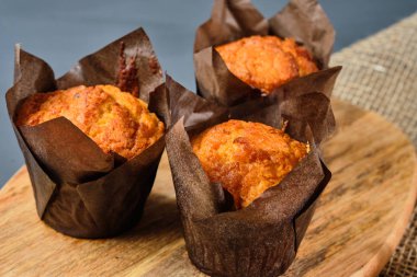 ahşap bir Tahta üzerinde cupcakes ve gri bir arka plan üzerinde çuval. Rustik stil