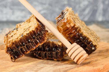 ahşap bir Tahta üzerinde bal ile petek ve bal için bir kaşık, seçici odak