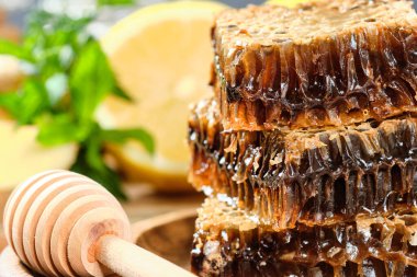 ahşap bir tabak ve ahşap bir arka plan üzerinde rustik tarzında limon ve zencefil ile fındık ile bal petek bal. Close