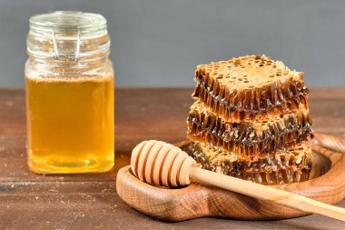 Tahta bir tabakta bal ve fındıklı kavanozlarda altın bal.