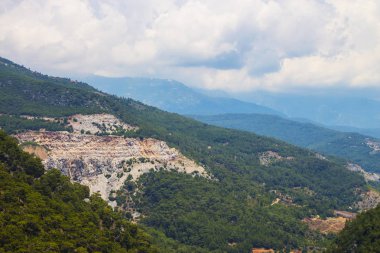 Dağ manzarası. Dağlardaki orman, mavi gökyüzüne karşı. Güney ülkelerine seyahat