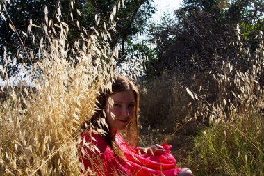 Deniz kenarında kırmızı elbiseli bir kız. Rüzgar, dalgalar, ıssız sahil. Güney 'de bir tatil