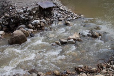 Dağ nehrinin hızlı akışı. Taşlar arasındaki su akışı. Dar bir dağ nehrinde rapids