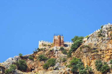 Gökyüzüne karşı bir kaya üzerinde taş kale. Dağdaki taş çit. Türkiye, Alanya 