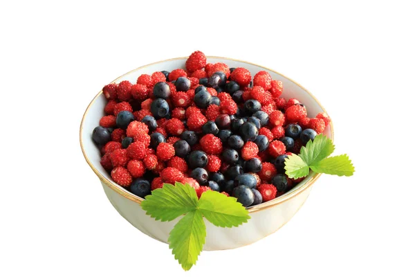 放在木制桌子上的白色陶瓷盘中的草莓和蓝莓 — 图库照片