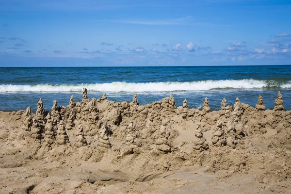 Sand castle on the blue sea. Beach games