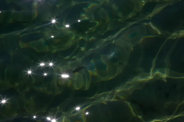 Záře slunečního světla na vodě. Pozadí, struktura vody a světla — Stock fotografie