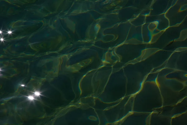 Záře slunečního světla na vodě. Pozadí, struktura vody a světla — Stock fotografie