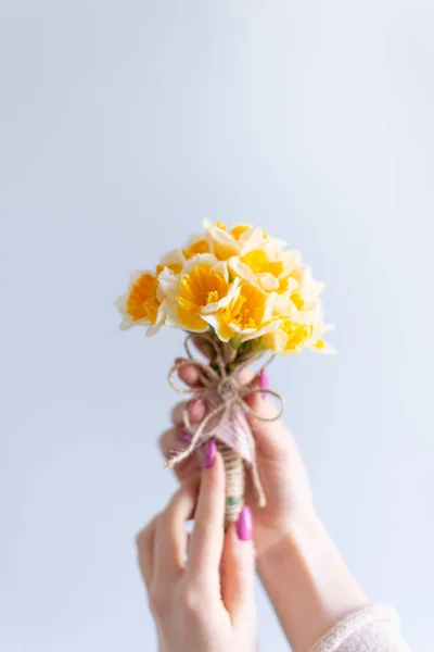 image of a girl holding a flower in her hands on a grey background