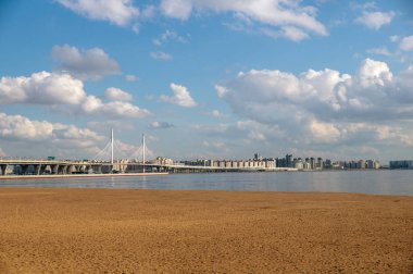 Güneşli bir yaz gününde köprü ve dolgu. Arka planda şehir binaları.