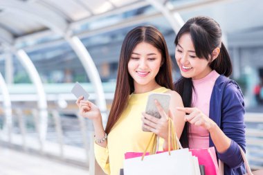 mutlu güzel genç kadın alışveriş keyfini çıkarın ve Kağıt alışveriş çantası ve cep telefonu dükkanında alışveriş merkezi şehir ve iş bölgesinin merkezinde satışında yaz şehirle tutun