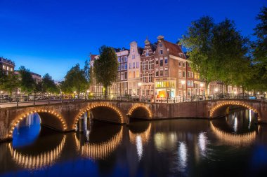 Hollanda Amsterdam City günbatımı zaman su yansıması ile Keizersgracht kanalı, tekne ve araba Caddesi ve nehir üzerindeki köprü ile ulaşım için ünlü kanal boyunca daire