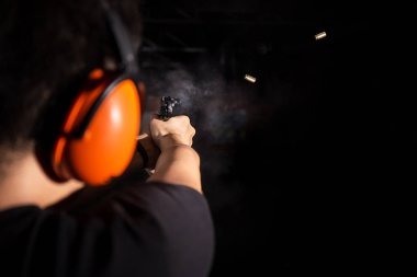 çekim tabanca silah adamım, kurşun sıkacağını ve turuncu kulak kapak aralığı çekim giymek