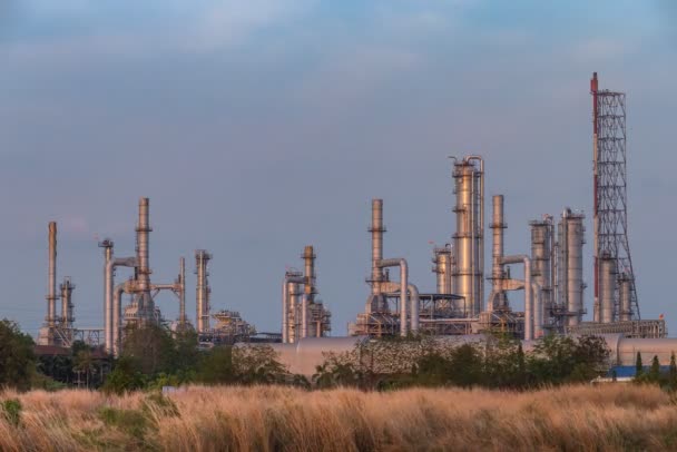 Día a noche lapso de tiempo de movimiento de nubes y puesta de sol detrás de la planta petroquímica y petrolera con reactor y destilación para proceso químico en área industrial — Vídeo de stock