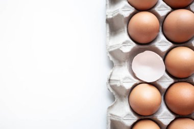Yumurta kutusunda taze tavuk yumurtasının yakın plan resmi, beyaz arka plan, yemek pişirmek için kırılgan bir yumurta kabuğu ve sağlıklı konsept için taze ve doğal yumurta kasesi.
