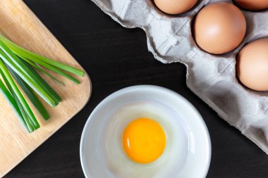 Tahta kasede taze tavuk yumurtası ve sağlıklı ve lezzetli yemek ya da yemek pişirme konsepti için ahşap mutfak masasında yumurta paketinde yumurta.