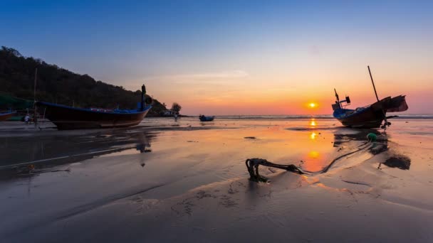 Upływ czasu mała łódź rybacka leżała na plaży i odbicie wody i żółty, pomarańczowy zachód słońca kolor na plaży w czasie zachodu słońca Tajlandii — Wideo stockowe