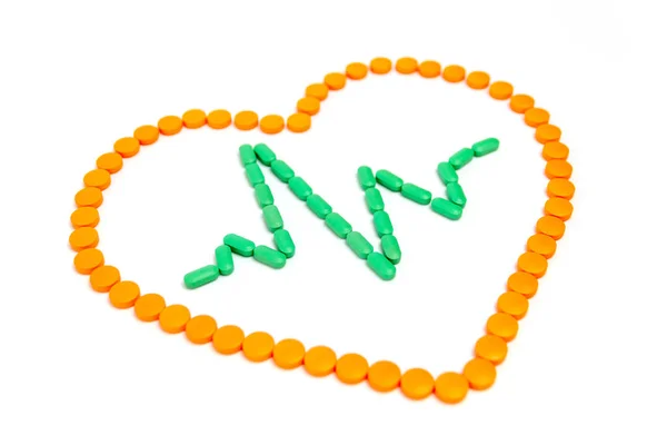 En puls är av gröna piller i det orangea hjärtat isolerade på vit bakgrund. — Stockfoto