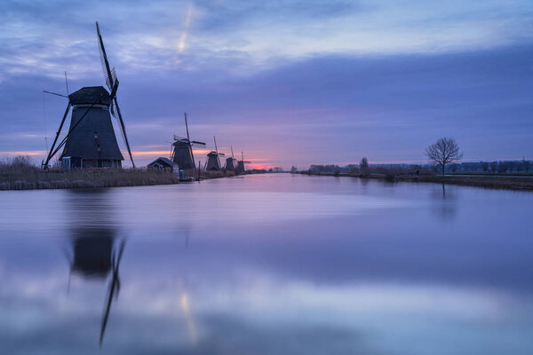 Kinderdijk, Alblasserdam, South Holland, Netherlands - February 20, 2019 : Sunrise on a cold morning in February at Kinderdijk, a Unesco World Heritage site because of the 19 well maintained windmills in the area.