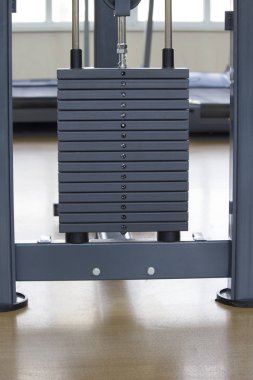 Spor salonunda ağır ağır siyah levhalar yığılmış. Spor simülatörü kalıpları