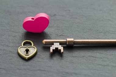 Bir kayrak taş arka plan üzerinde anahtar ile Kalp şeklinde asma kilit . kalp kavramından anahtar